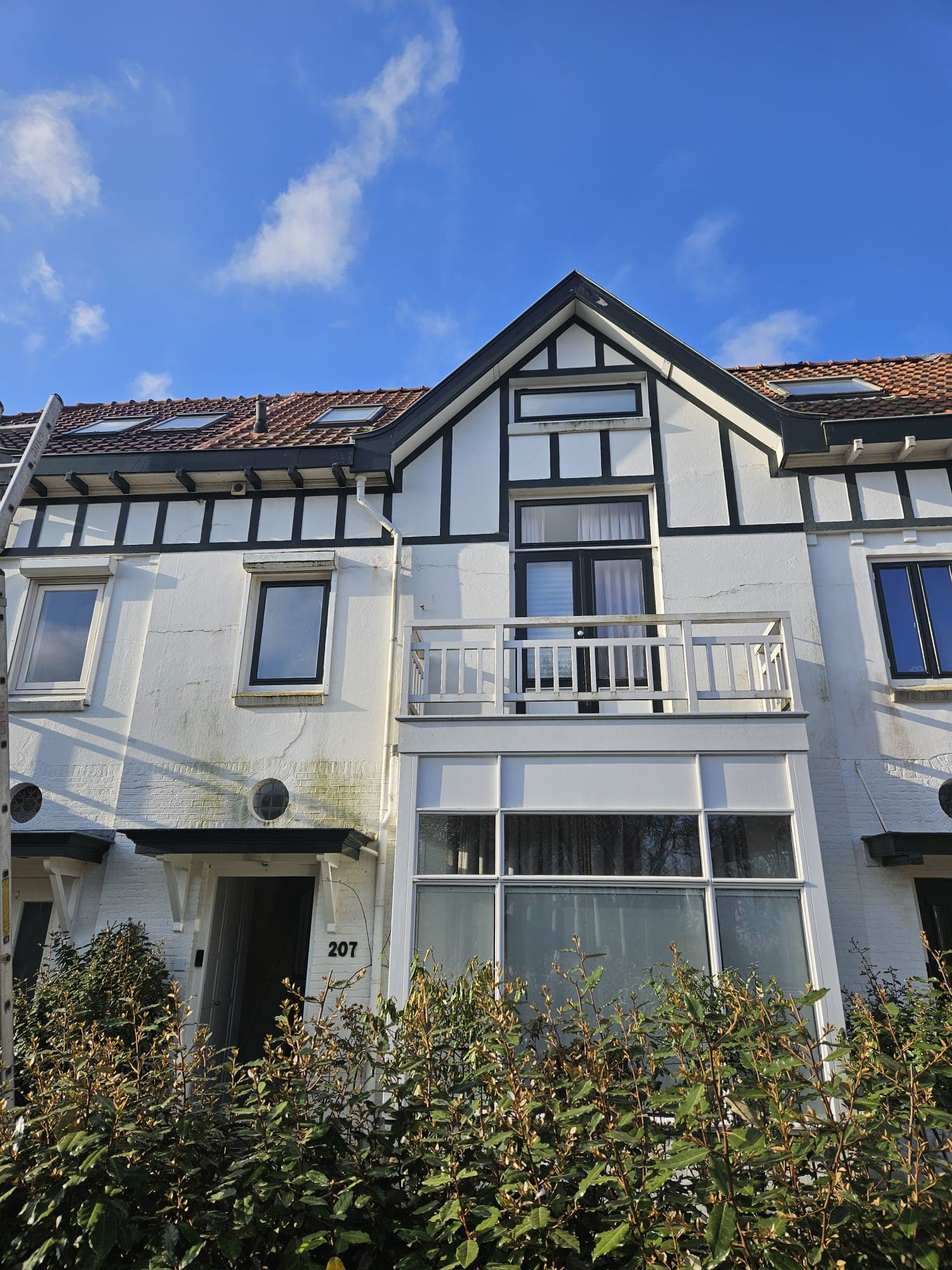 Ladder tegen een jaren-twintig herenhuis in Vlissingen tijdens het glazenwassen door Mooi Huis Zeeland