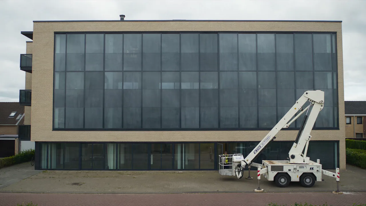 Glazenwassen van een kantoorpand met hoogwerker in Zeeland